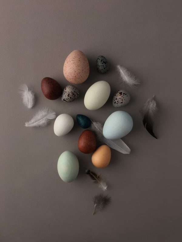 A dozen handmade wooden bird eggs in a basket - Moon Picnic & Erzi